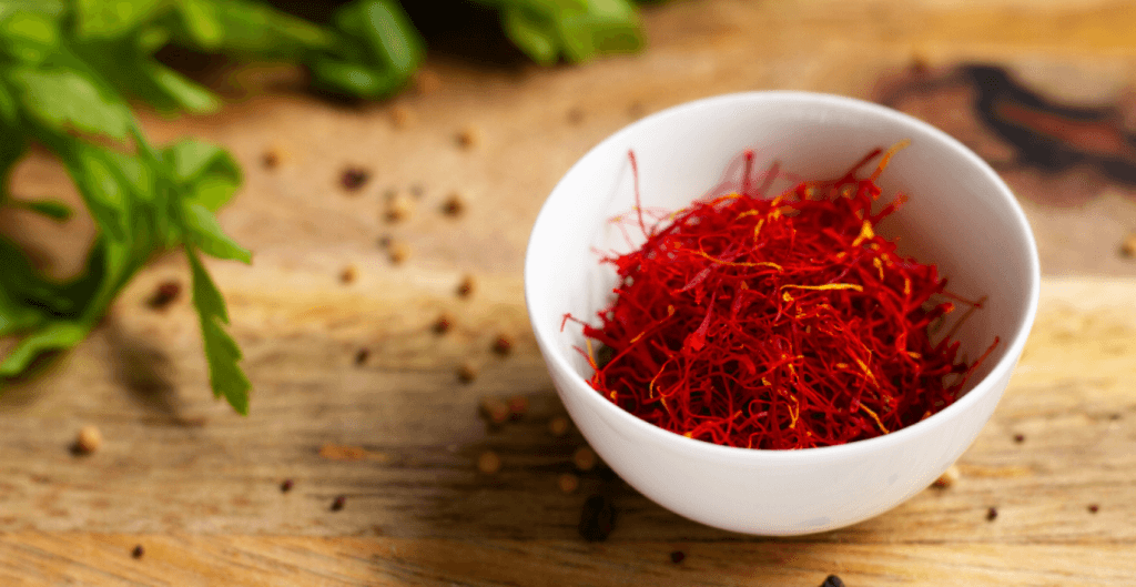 close-shot-of-a-white-bowl-of-a-premium-saffron-with-green-leaves-aside