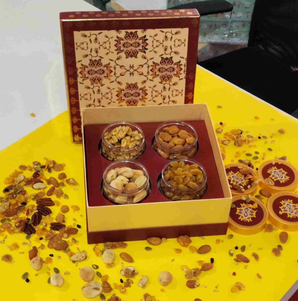 Sufyan Heritage Maroon and Gold 4-Jar Dry Fruit Gift Box featuring clear jars filled with walnuts, almonds, cashews, and raisins with Mughal ornamental lid artwork